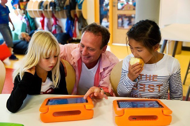 A teacher helps his students with their iPads at the Steve Jobs school in Sneek